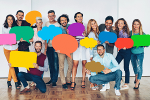 A diverse group of people holding speech bubbles and smiling.